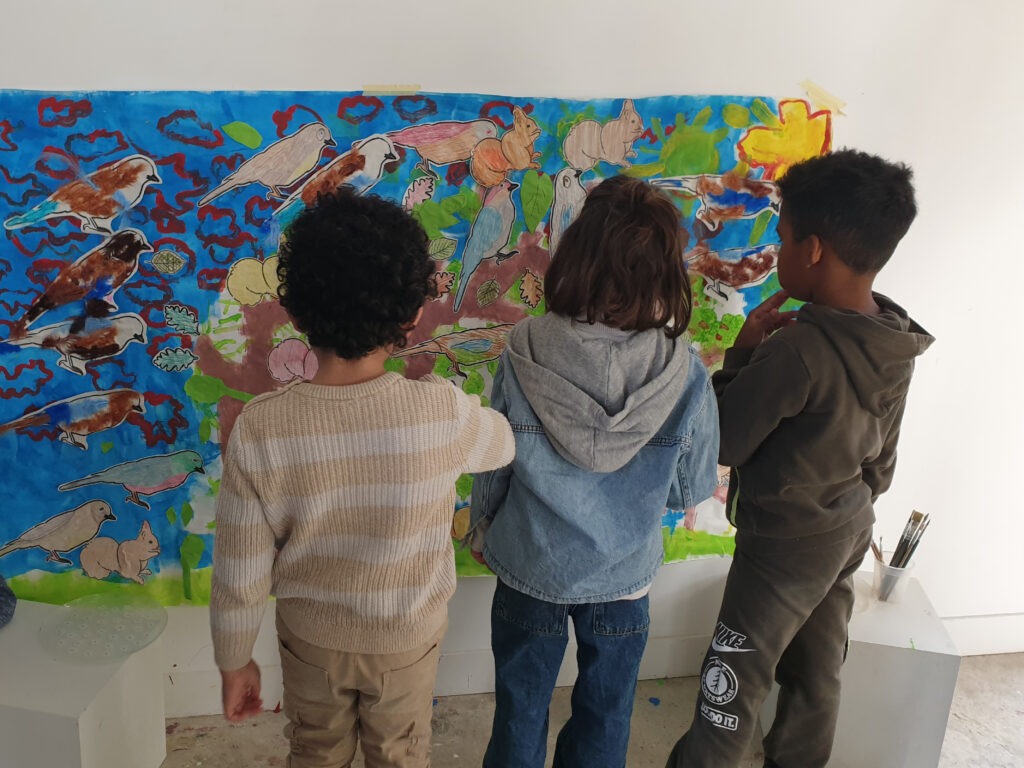 enfants devant une grande illustration peinte