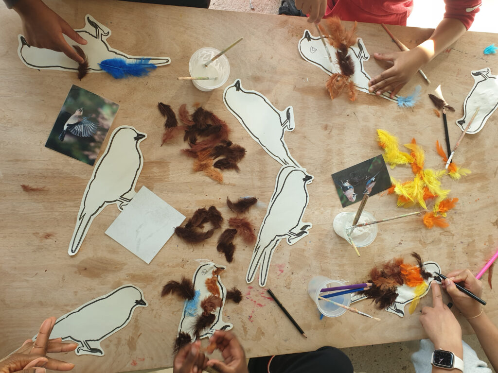 enfant collant des plumes pour un petit atelier