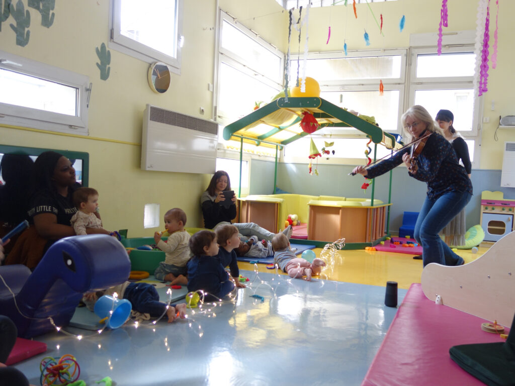 violoniste devant des bébés à la crèche